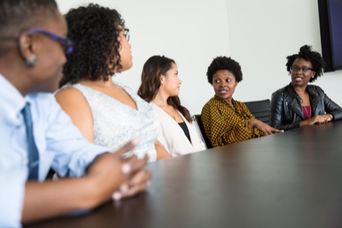 diverse men and women talking in conference room.